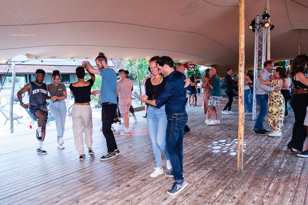 Verschillende koppels dansen Kizomba op een Kizomba party in open lucht op een houden dansvloer.