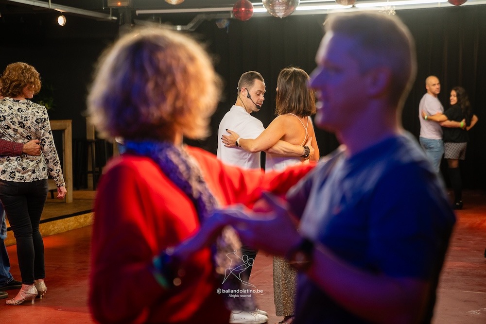 Verschillende koppels volgen dansles bij Bailando Latino.